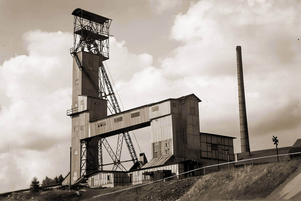 Zeigt den Förderschacht und das Schachtgebäude der Eisenerzgrube Schmiedefeld in Thüringen.