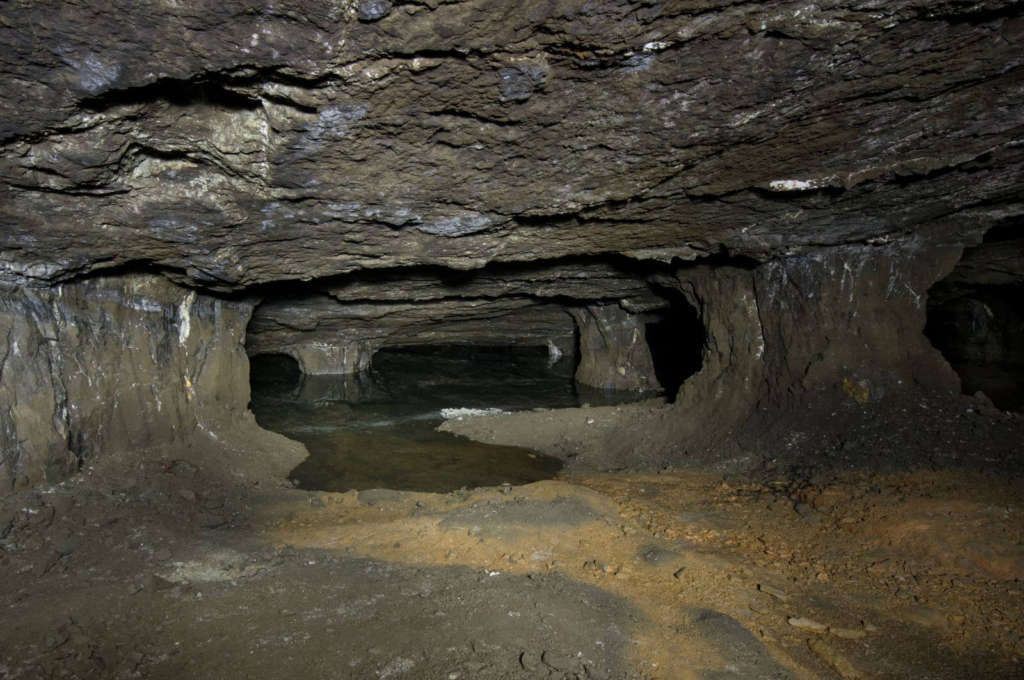 Zeigt einen Kammer-Pfeilerbau, der ins Wasser läuft und so einen See bildet.