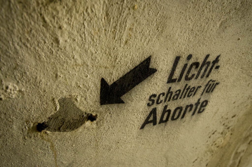 Wandbeschriftung, Pfeil mit dem Hinweis "Lichtschalter für Aborte"