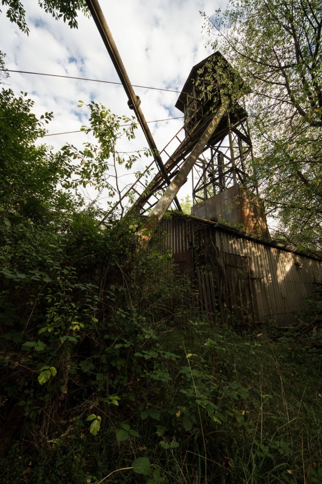 Zeigt den Förderturm von vorn im abendlichen Sonnenlicht.