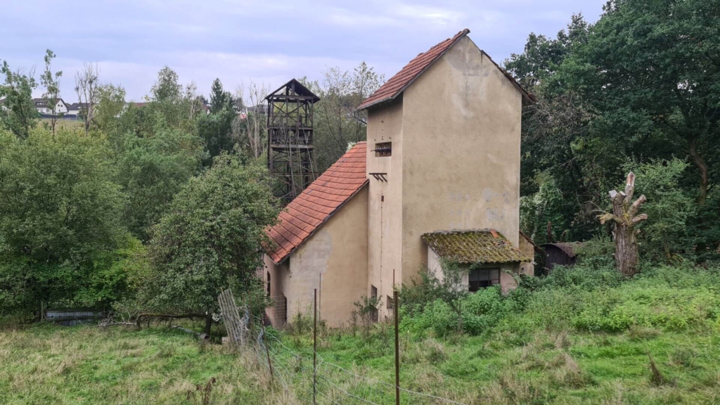 Blick auf das Maschinenhaus und den Förderturm im Hintergrund.