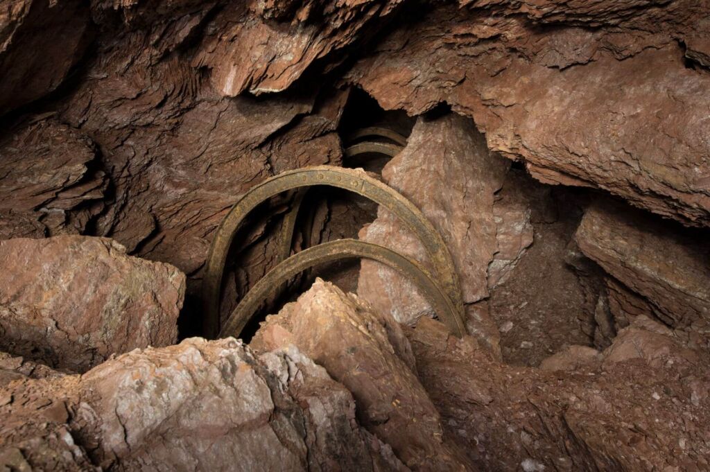 Zeigt einen stark kollabierten Stollen mit riesigen Steinen, welche aus der Firste gebrochen sind.