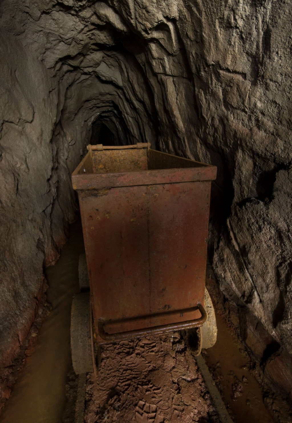 Zeigt einen Förderwagen, der auf den Gleisen im Wasserlösestollen steht.