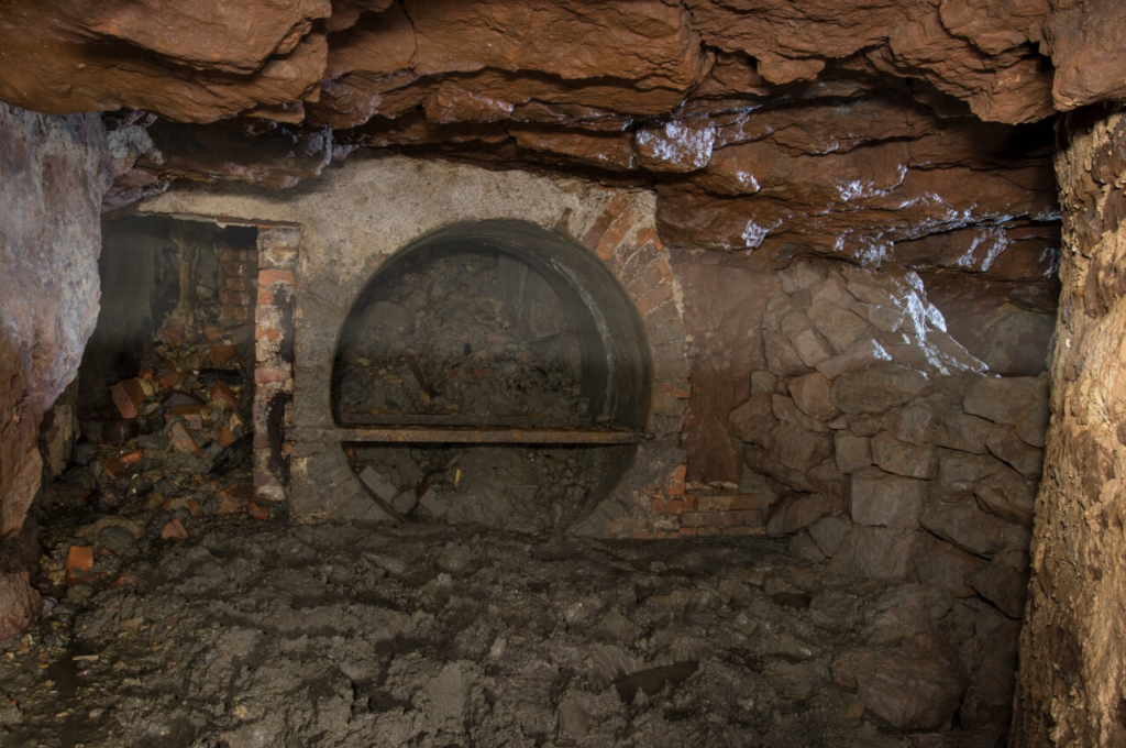 005-tortenstollen Zeigt Teile der alten Bewetterung und die runde Betoneinfassung für den Ventilator.