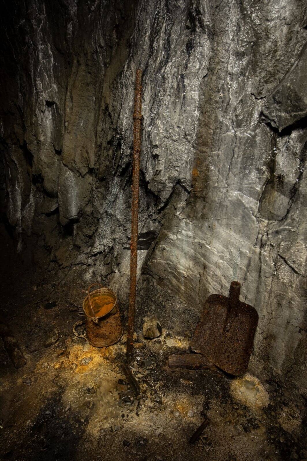 Zeigt rostiges zurückgelassenes Werkzeug wie Bohrstange, Schaufelblatt und Eimer.