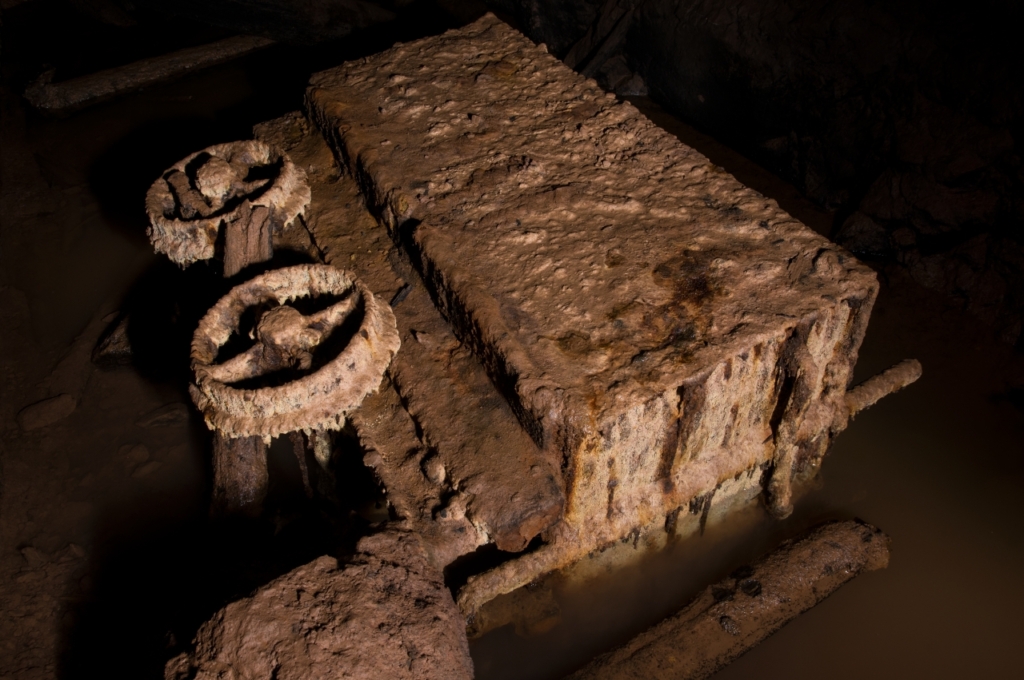 rostiger und umgekippter Förderwagen, der im Wasser liegt