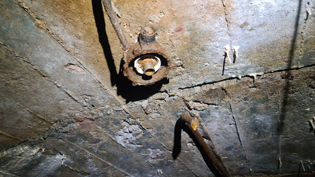 Zeigt eine weitere Lampenfassung an der Betondecke des Förderstollens.