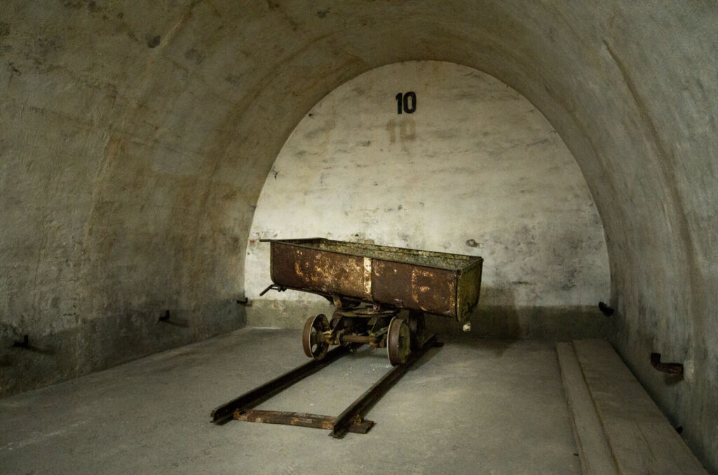Förderwagen im Luftschutzstollen auf Schienen, wie er beim Bau verwendet wurde.