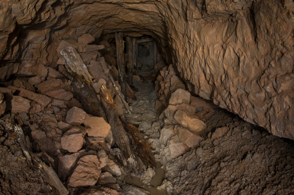 009-tortenstollen zeigt den Stollen direkt vor dem Verbruch. Links und rechts liegen Steine und Erde, welche aus dem Verbruch gezogen wurden.
