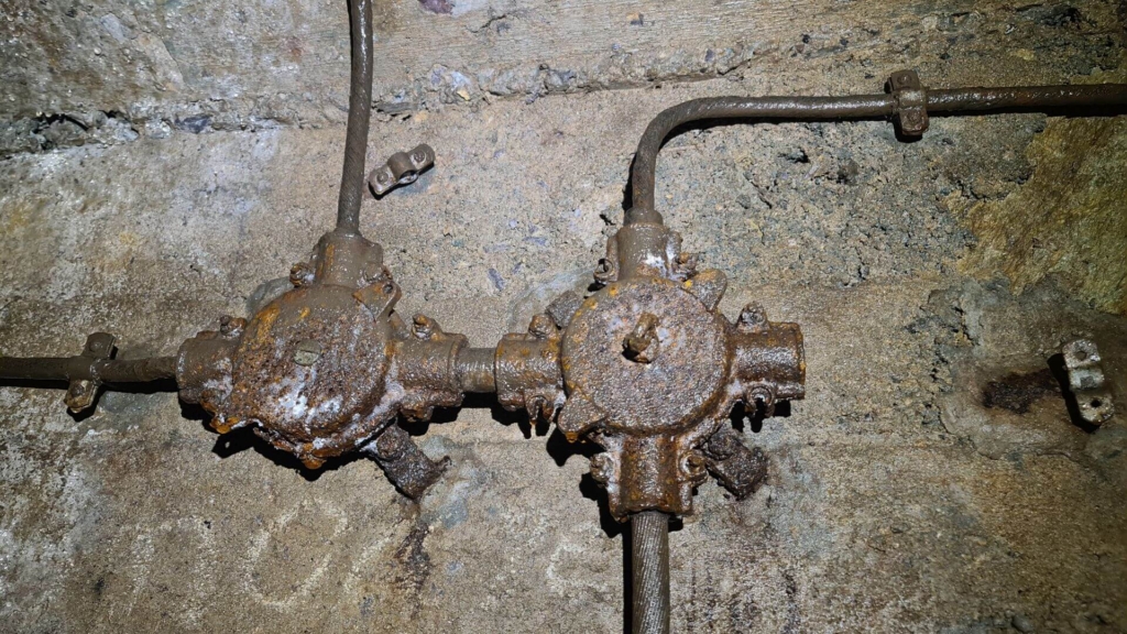 Zu sehen sind zwei Bakelit Stromverteilerdosen, welche an der Wand im Förderstollen installiert wurden.