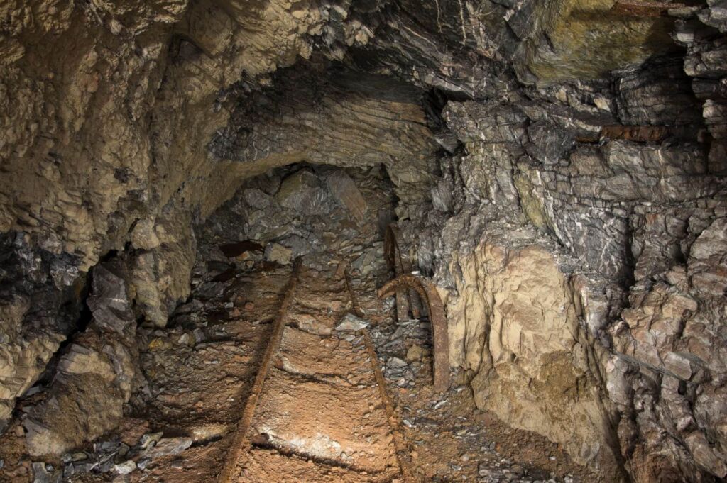 Zu sehen ist eine Strecke mit starkem Verbruch. Am Ende der Strecke ist der Stollen komplett kollabiert.