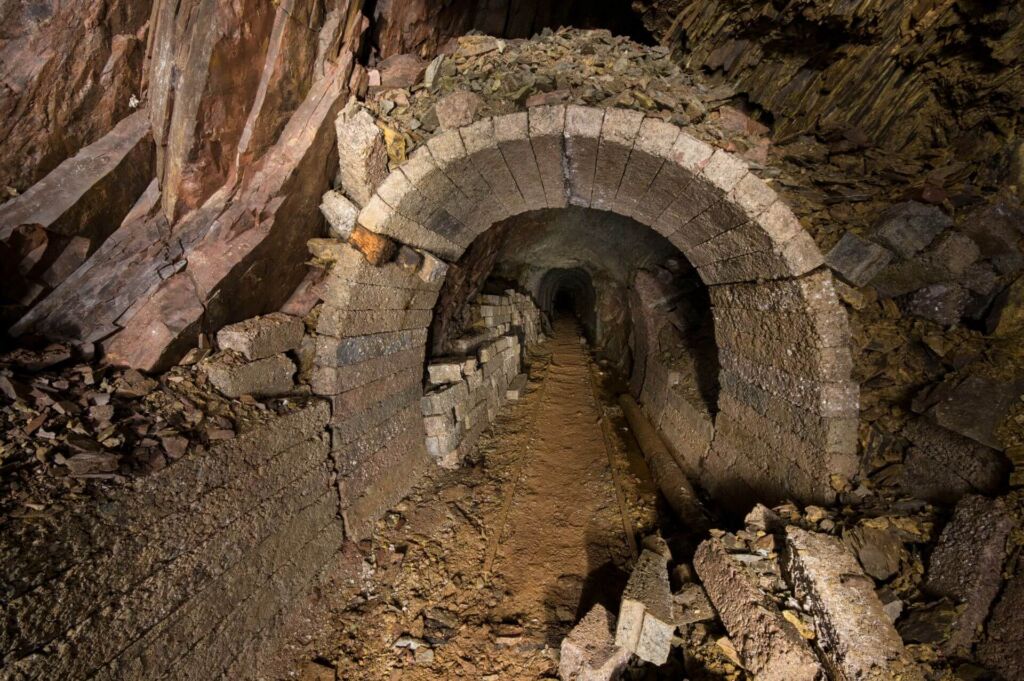 Zeigt einen Altbergbau-Stollen mit einem Ausbau aus Betonfertigteilen.