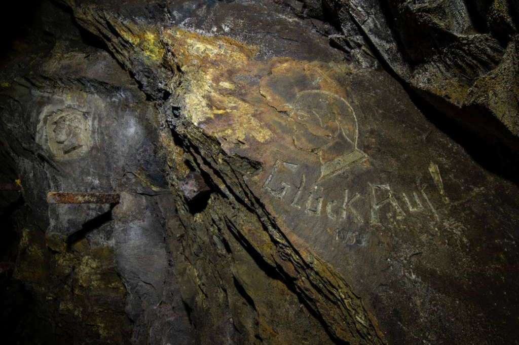 Zeigt beide Reliefs an der Wand im Stollen.