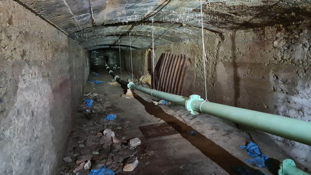 Blick in den betonierten Förderstollen. Im Stollen hängt ein Rohr, welches in den gefluteten Schacht führt und der Feuerwehr als Ansaugstelle dient.