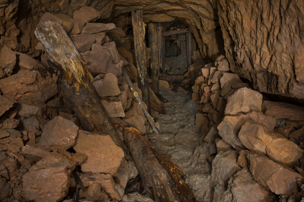 015-tortenstollen zeigt den Stollen direkt vor dem Verbruch. Links und rechts liegen Steine und Erde, welche aus dem Verbruch gezogen wurden.