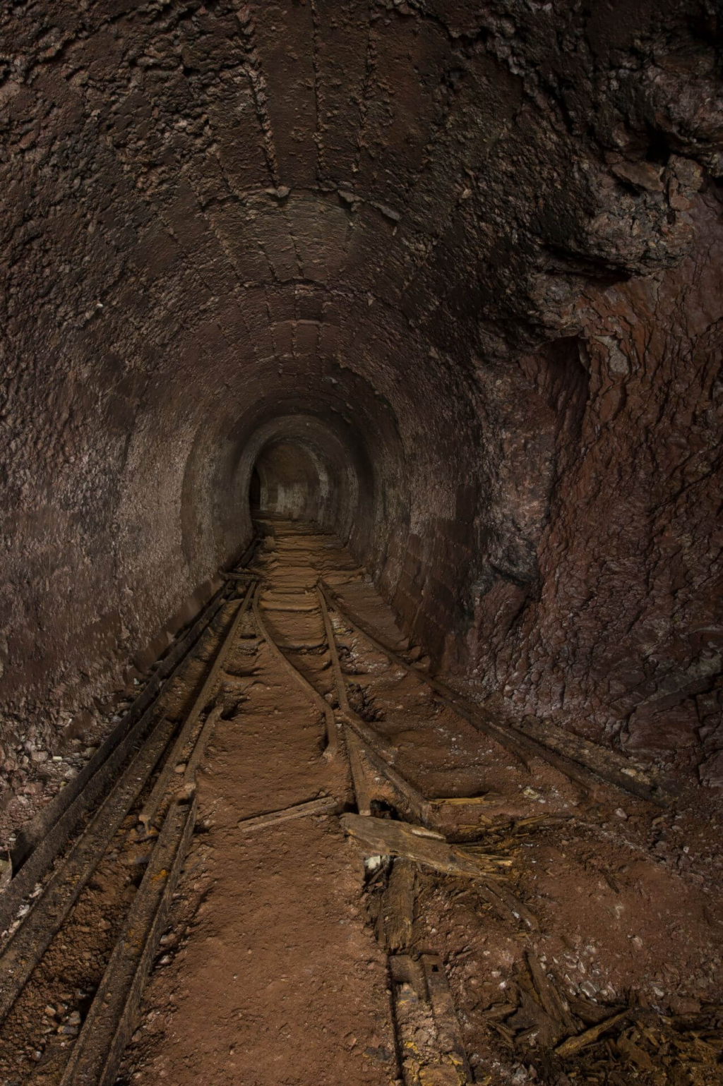 Zeigt eine Weiche im Altbergbau-Stollen. Der Stollen ist in Beton ausgebaut und hat eine runde Form.