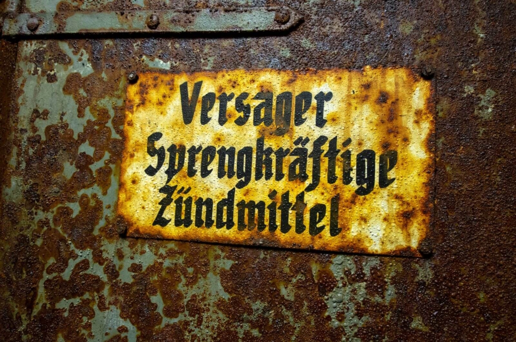 Zeigt ein Metallschild an einer Tür, auf dem steht "Versager Sprengkräftige Zündmittel"