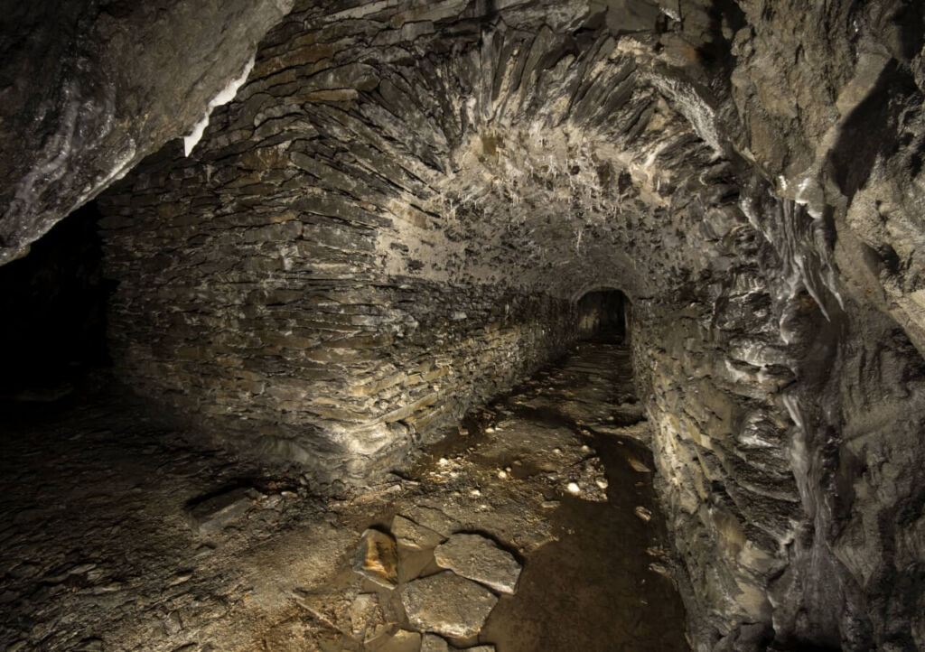 006-schiefergrube-barbaras-treppchen-gewoelbemauerung Langer Stollen mit Bogenmauerung durch den Abbau.