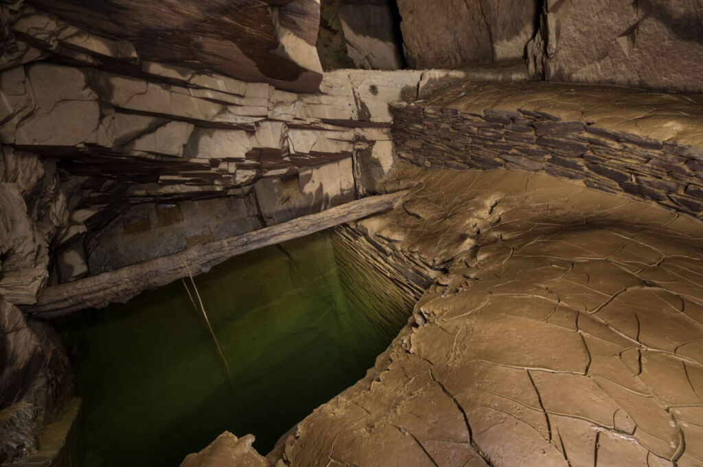 Gesenk mit grünlichem Wasser und Trockenmauerung