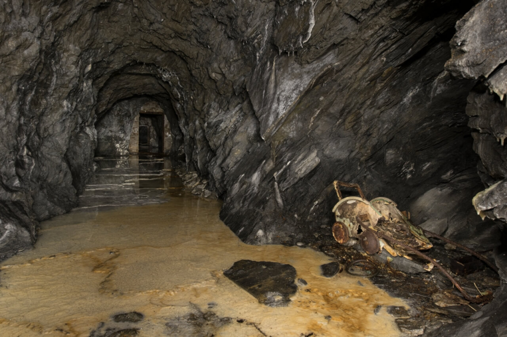 Zeigt den Stollen in Blickrichtung Sprengmittellager, die Sohle ist stark versintert.
