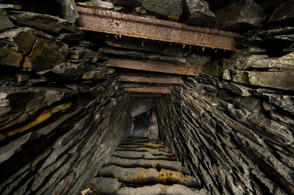 Zeigt die Schiefertreppe, welche in den Abbau führt. Auf der Treppe sitzt eine Person als Größenvergleich.