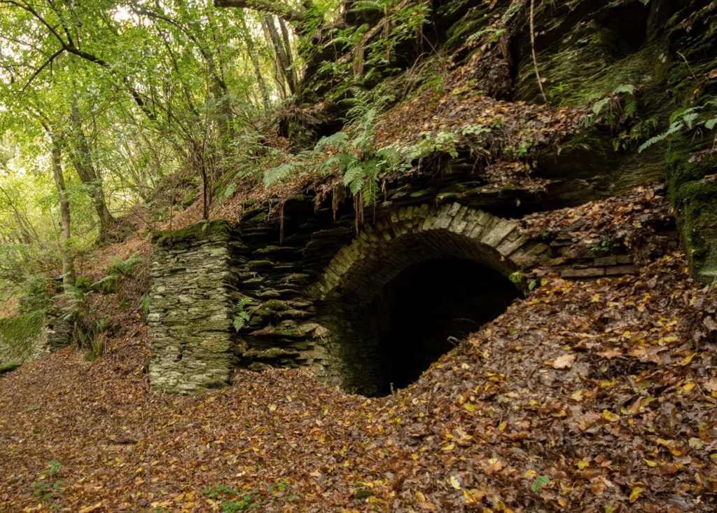 Mundloch in einer Schieferwand mit Bogenausbau