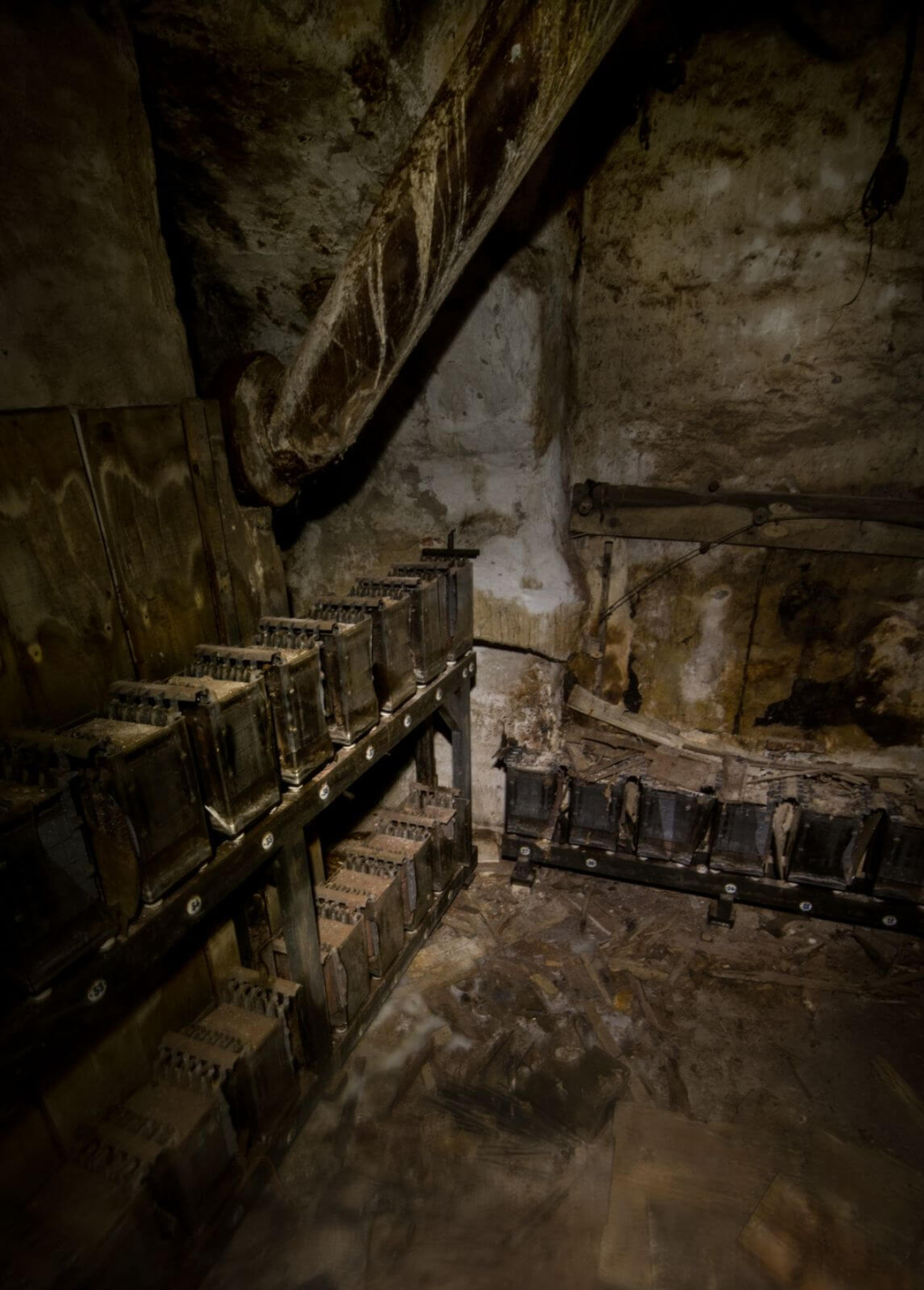 Zeigt alte Bleiakkus auf alten Holzregalen in einer verlassenen Fabrik.