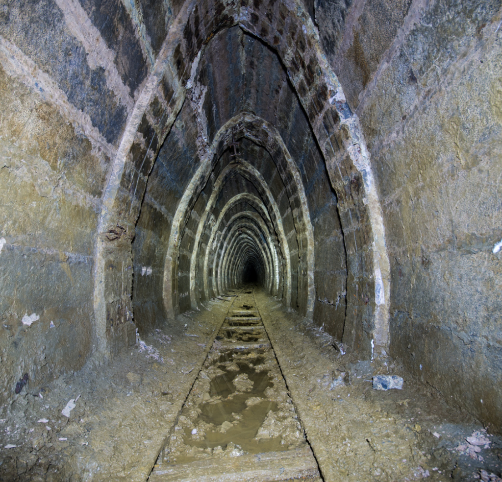 011_ei Zeigt einen Stollen, der mit Beton ausgebaut ist. Die Form des Ausbaus ähnelt einem spitzen Ei.