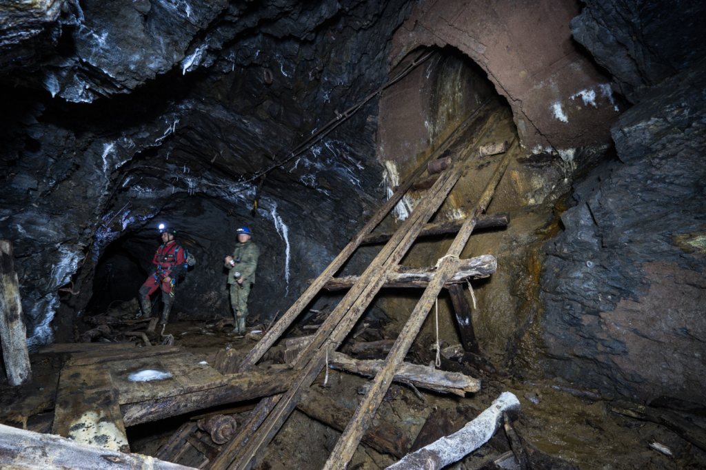 019_bremsberg_50mS_3 Zeigt den Schrägschacht auf der 50 m Sohle, im Hintergrund stehen 2 Personen im Stollen.
