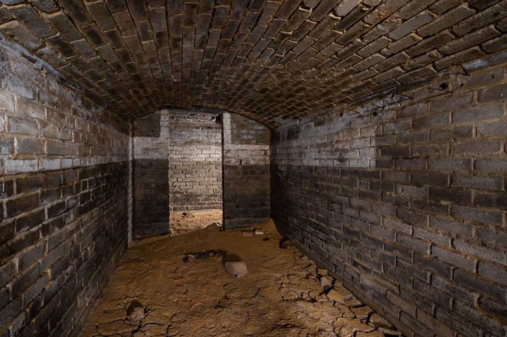 Schutzraum im Nordstollen mit Blick auf den Gang, der Boden ist schlamig.