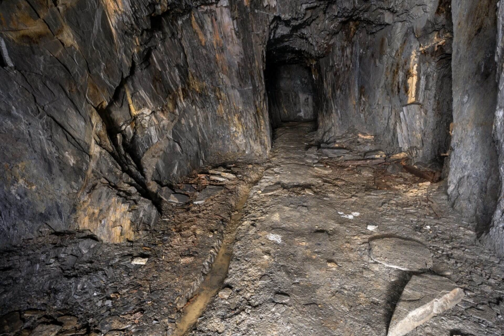 Stollen obere Sohle mit deutlich erkennbarer Rösche zur Wasserableitung.