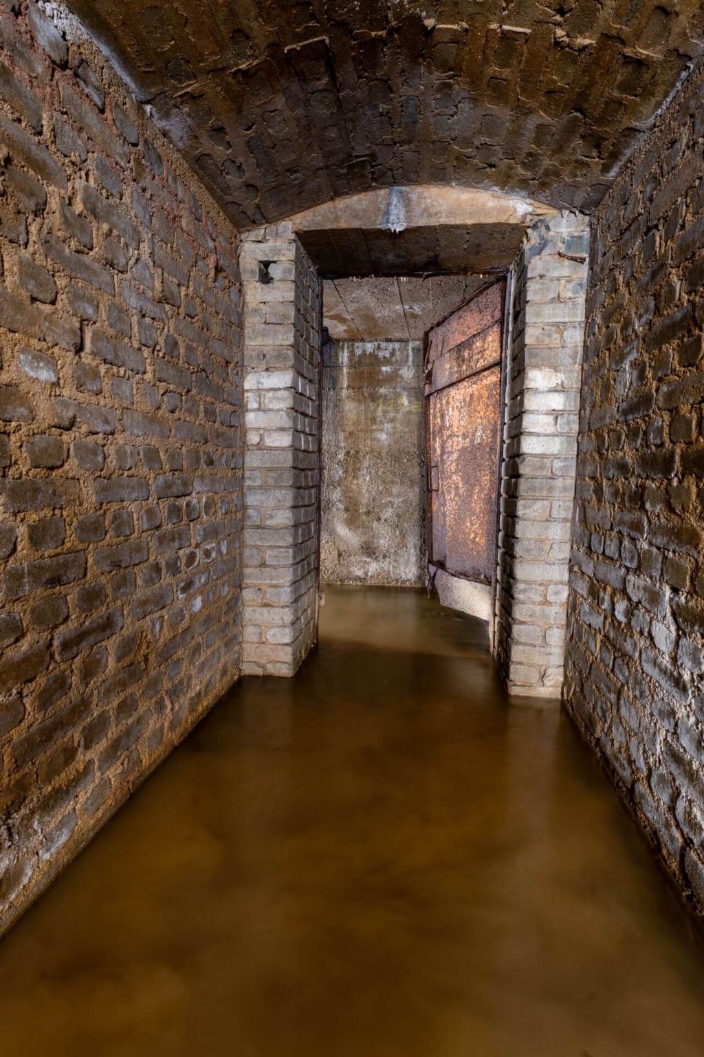 Verrostete Stahltür zum Ausgang, im Stollen steht 30 cm Wasser.