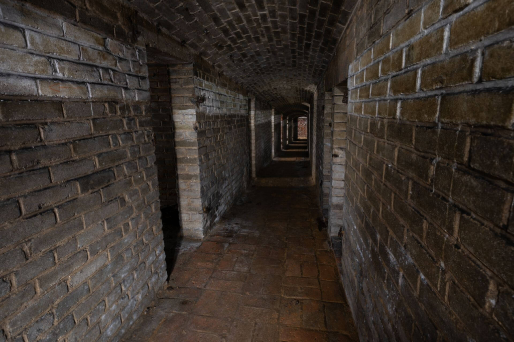 Gang im Nordstollen, welcher mit Ziegelsteinen ausgemauert ist, links die Türen zu den Schutzräumen.