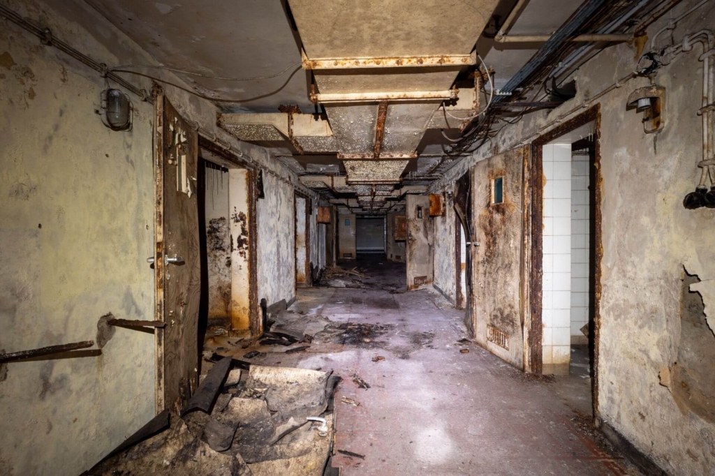 Langer Flur im Untergeschoss mit großem Lüftungsschacht in der Decke.