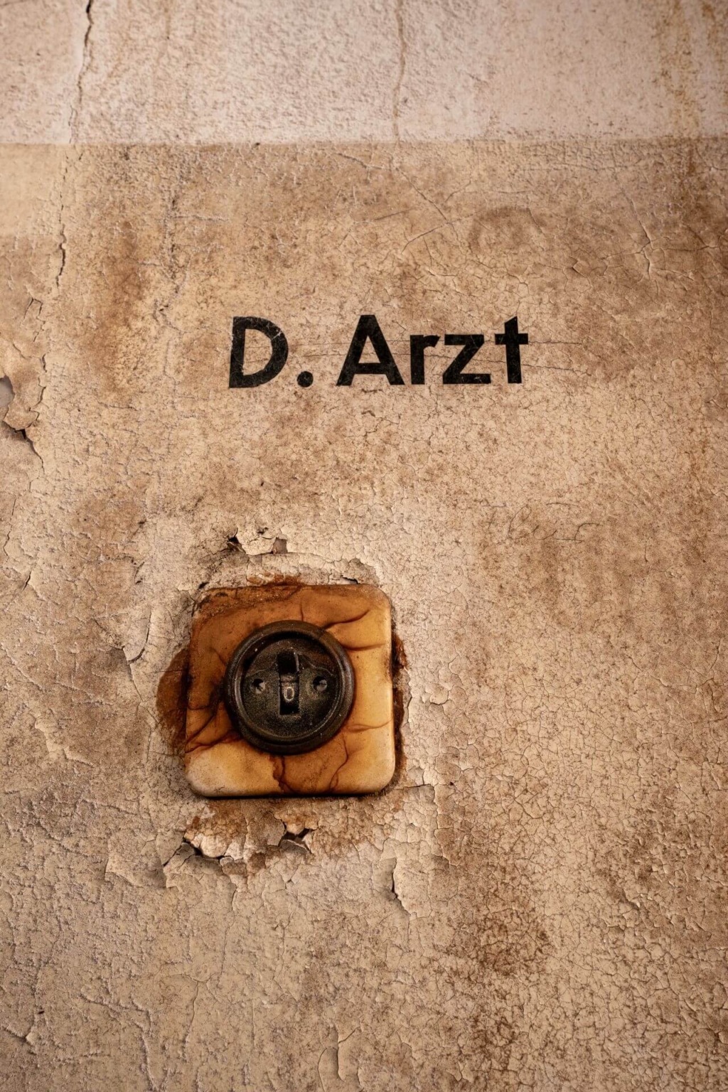 Beschriftung an der Wand über einen Lichtschalter "D-Arzt"