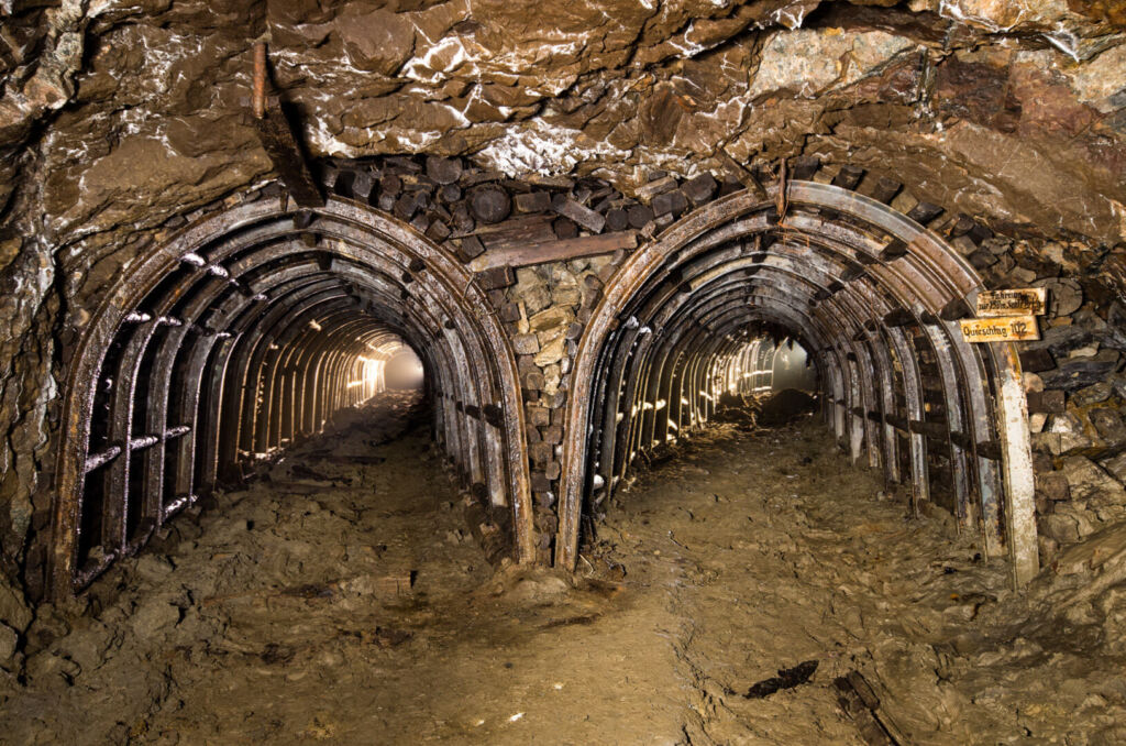 036_die zwei_wege Zeigt einen Streckenabzweig im Stahlsegmentausbau, aus beiden Stollen strahlt licht.