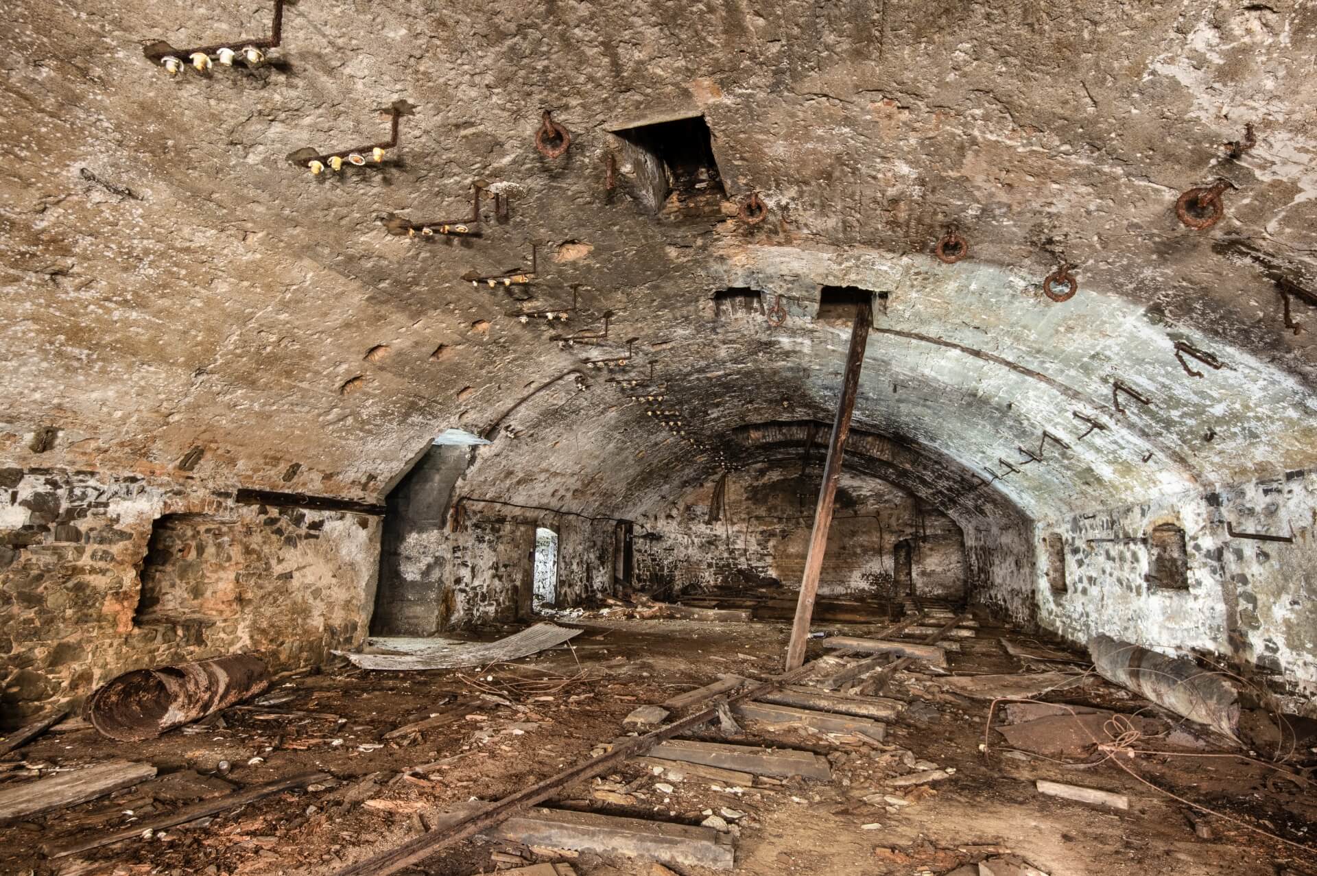 Zeig die riesige untertägige Halle des Füllorts mit Isolatoren der alten Stromleitungen an der Decke.